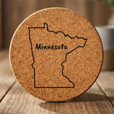 Minnesota round cork coaster engraved with the state outline and MINNESOTA in hand-drawn brush lettering