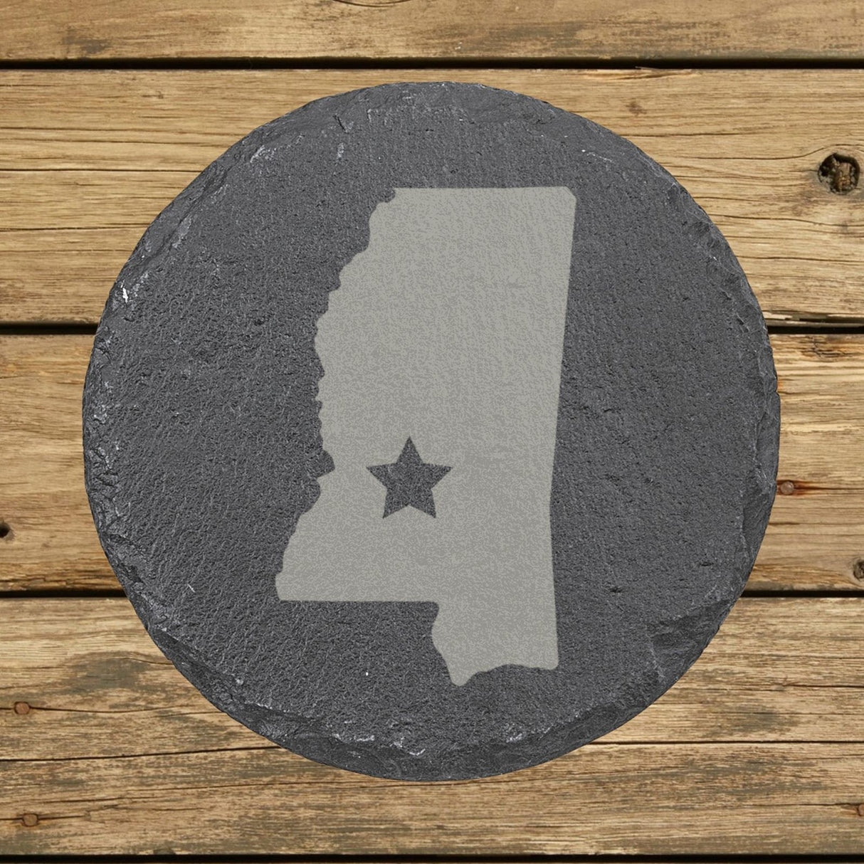 Mississippi round slate coaster engraved with the state shape and a star