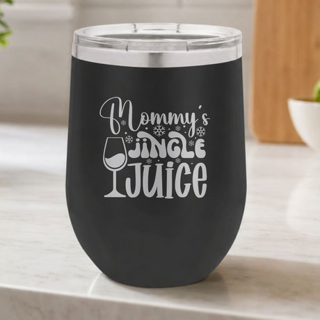 Black 12 oz stemless wine tumbler laser engraved with "Mommy's Jingle Juice", on a kitchen counter