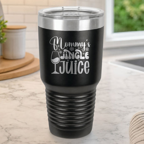 Black 30 oz tumbler laser engraved with "Mommy's Jingle Juice", on a kitchen counter