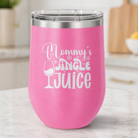 Pink 12 oz stemless wine tumbler laser engraved with "Mommy's Jingle Juice", on a kitchen counter