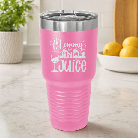 Pink 30 oz tumbler laser engraved with "Mommy's Jingle Juice", on a kitchen counter