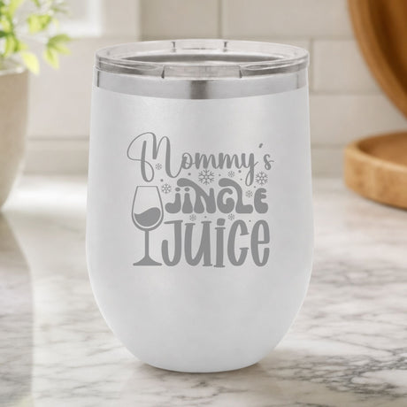 White 12 oz stemless wine tumbler laser engraved with "Mommy's Jingle Juice", on a kitchen counter
