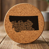 Montana round cork coaster engraved with the state shape in ornate floral scrollwork