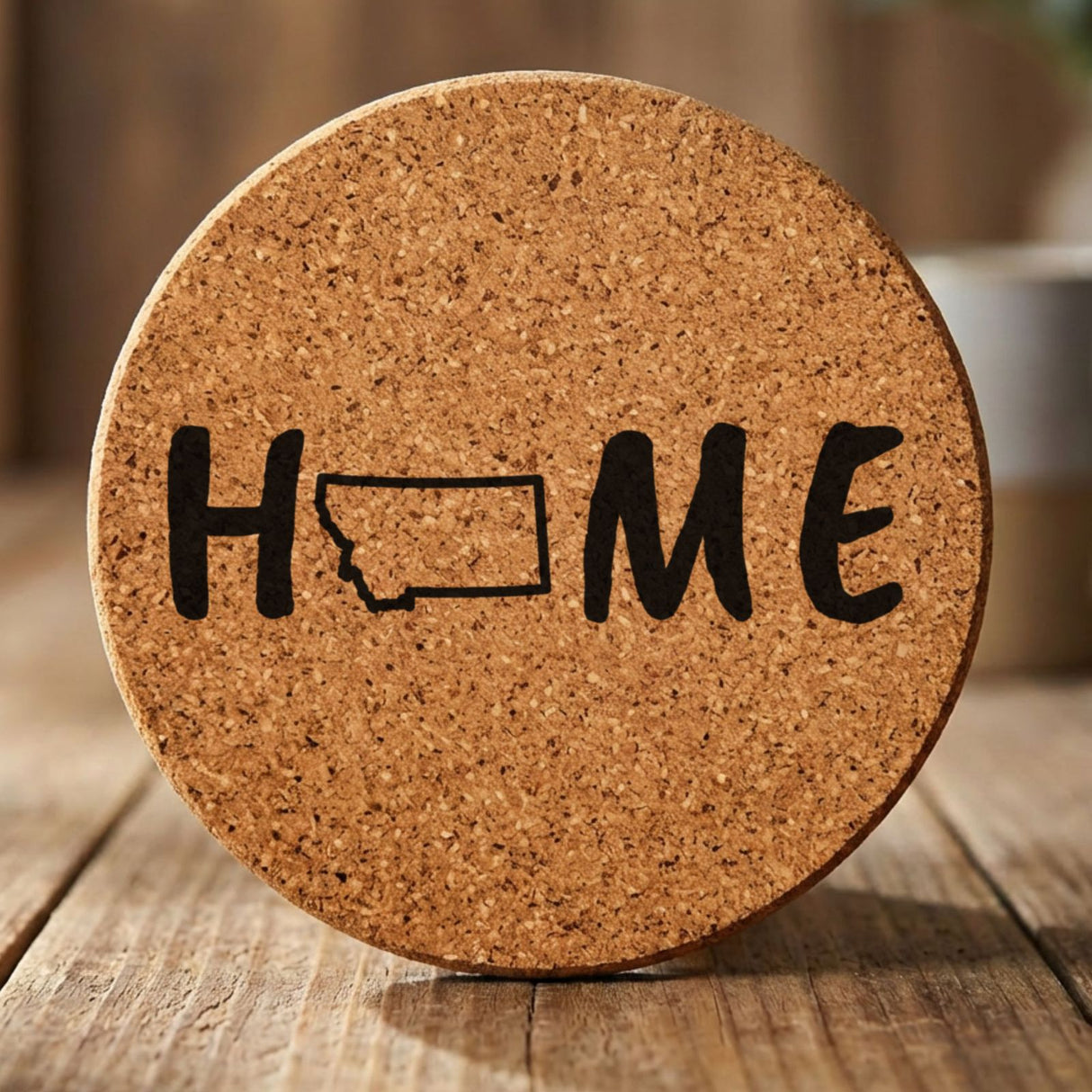 Montana round cork coaster engraved with HOME using the state outline as the letter O