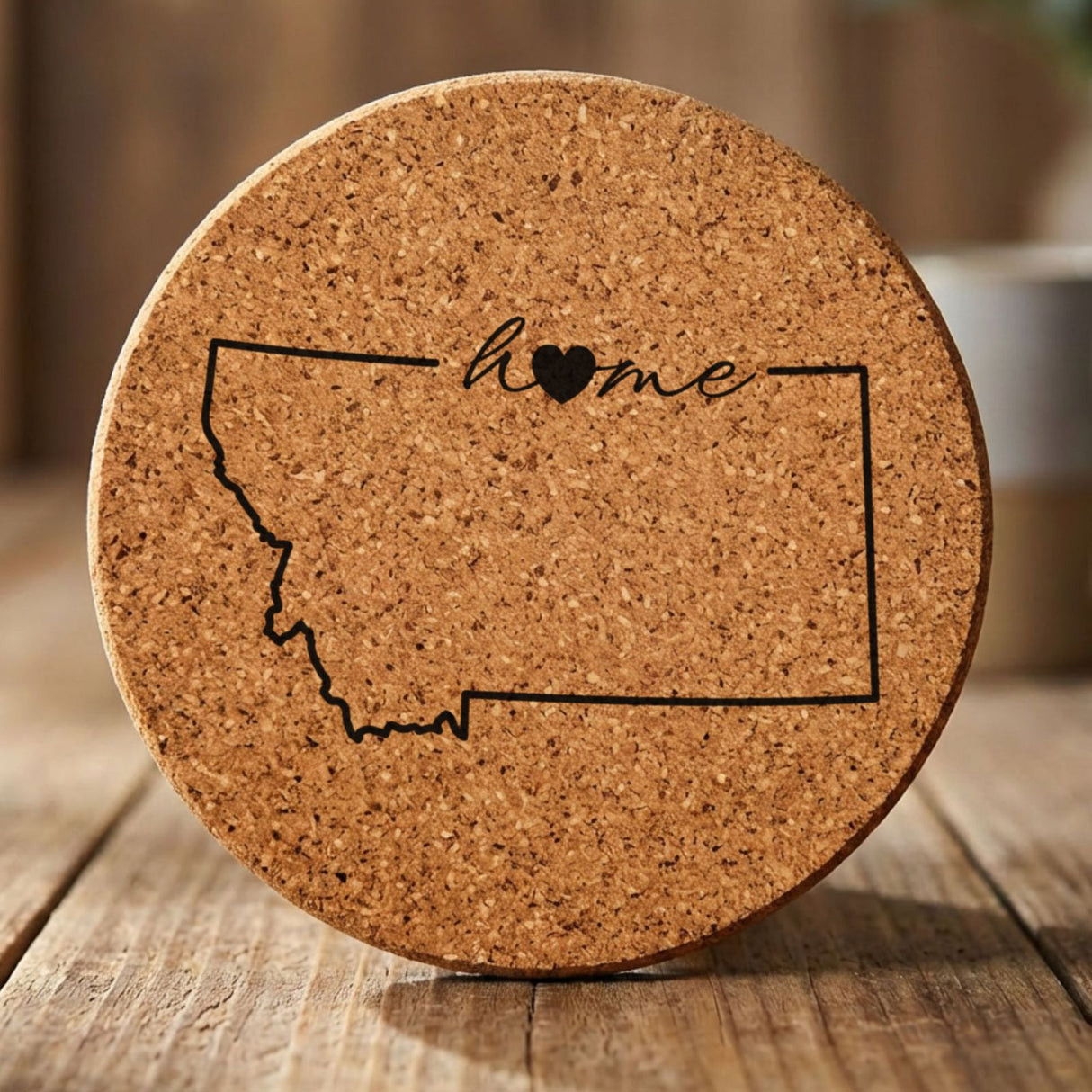 Montana round cork coaster engraved with the state outline and home in script with a heart