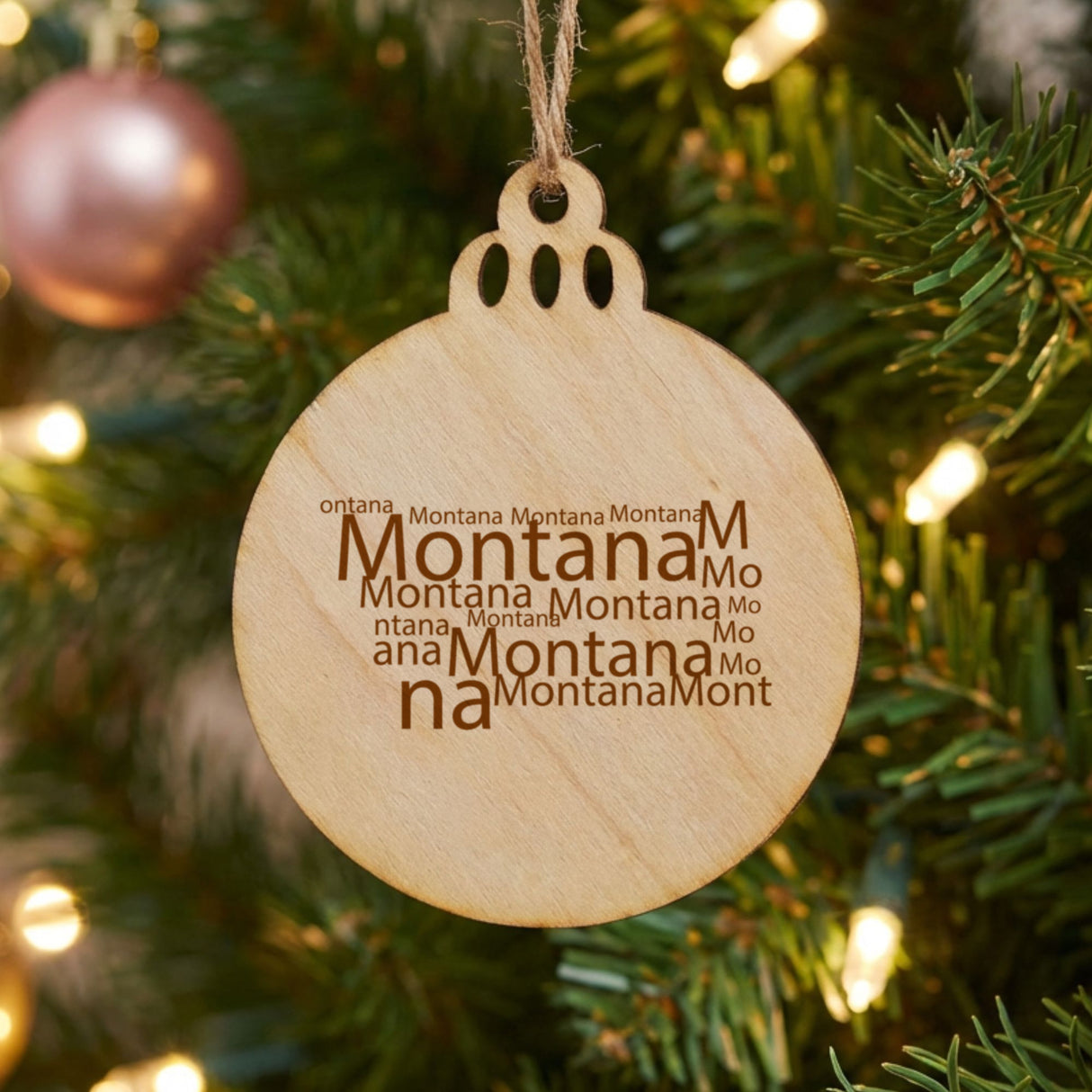 Montana round wood Christmas ornament engraved with a word cloud of repeating Montana text