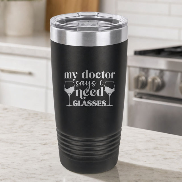 Black 20 oz tumbler laser engraved with "My Doctor Says I Need Glasses", on a kitchen counter