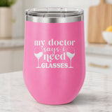 Pink 12 oz stemless wine tumbler laser engraved with "My Doctor Says I Need Glasses", on a kitchen counter