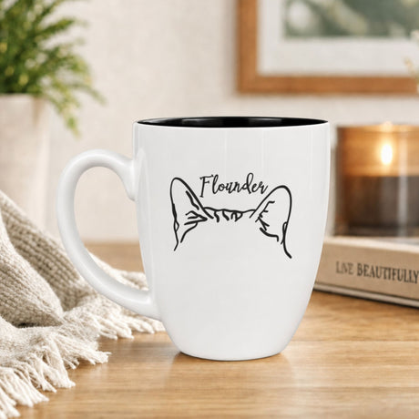 White 16 oz ceramic custom cat mug with cat ears, shown with a sample pet name