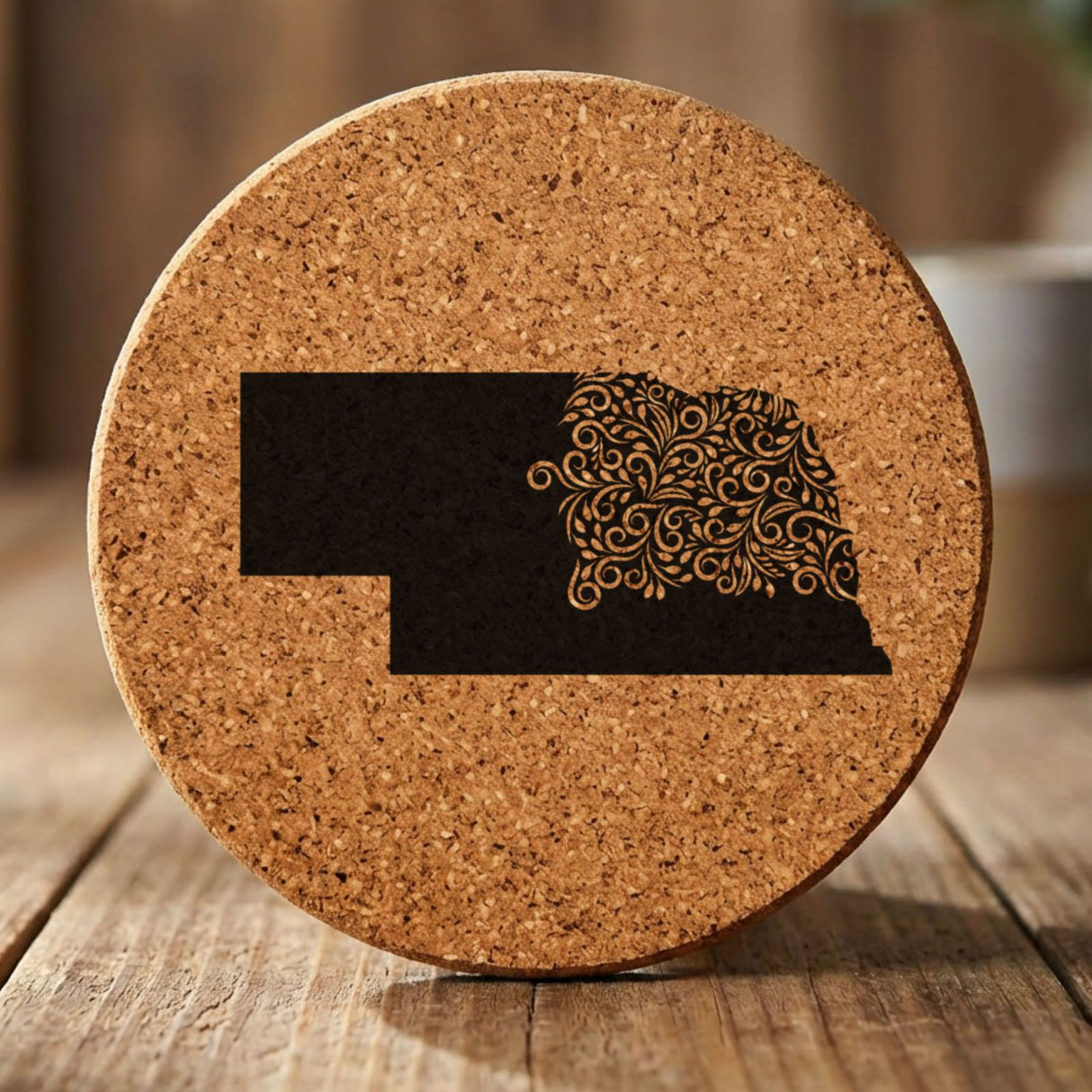 Nebraska round cork coaster engraved with the state shape in ornate floral scrollwork