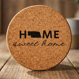 Nebraska round cork coaster engraved with HOME sweet home using the state shape as the letter O
