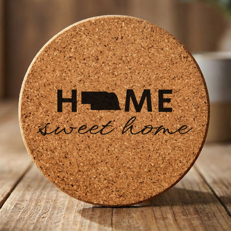 Nebraska round cork coaster engraved with HOME sweet home using the state shape as the letter O