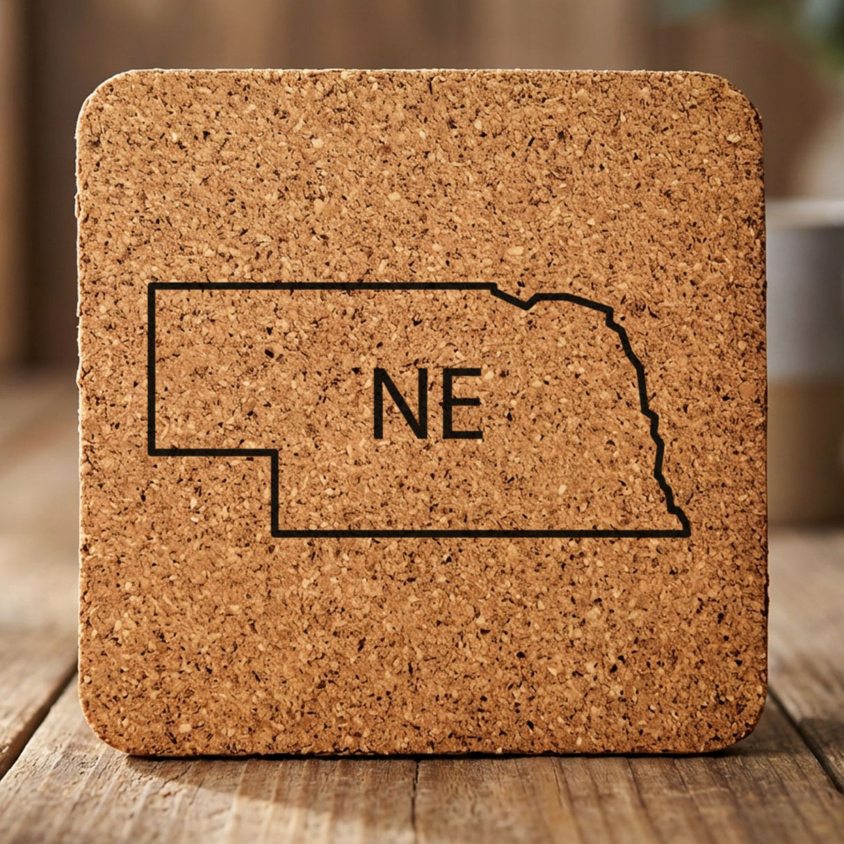 Nebraska square cork coaster engraved with the state outline and NE initials