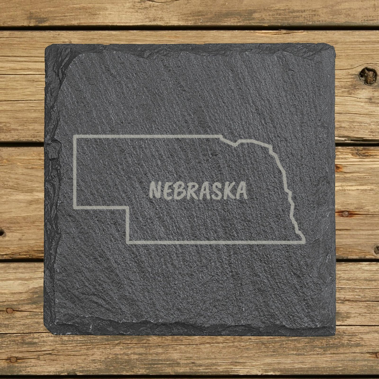 Nebraska square slate coaster engraved with the state outline and NEBRASKA in hand-drawn brush lettering