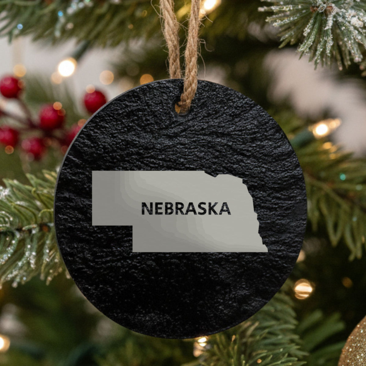 Nebraska round slate Christmas ornament engraved with the state shape and NEBRASKA in bold lettering