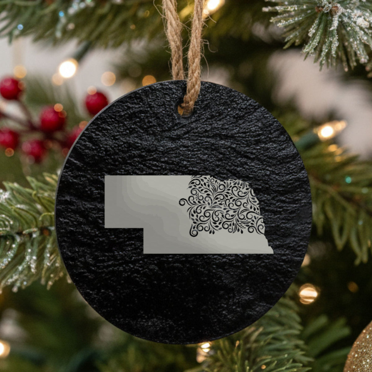 Nebraska round slate Christmas ornament engraved with the state shape in ornate floral scrollwork
