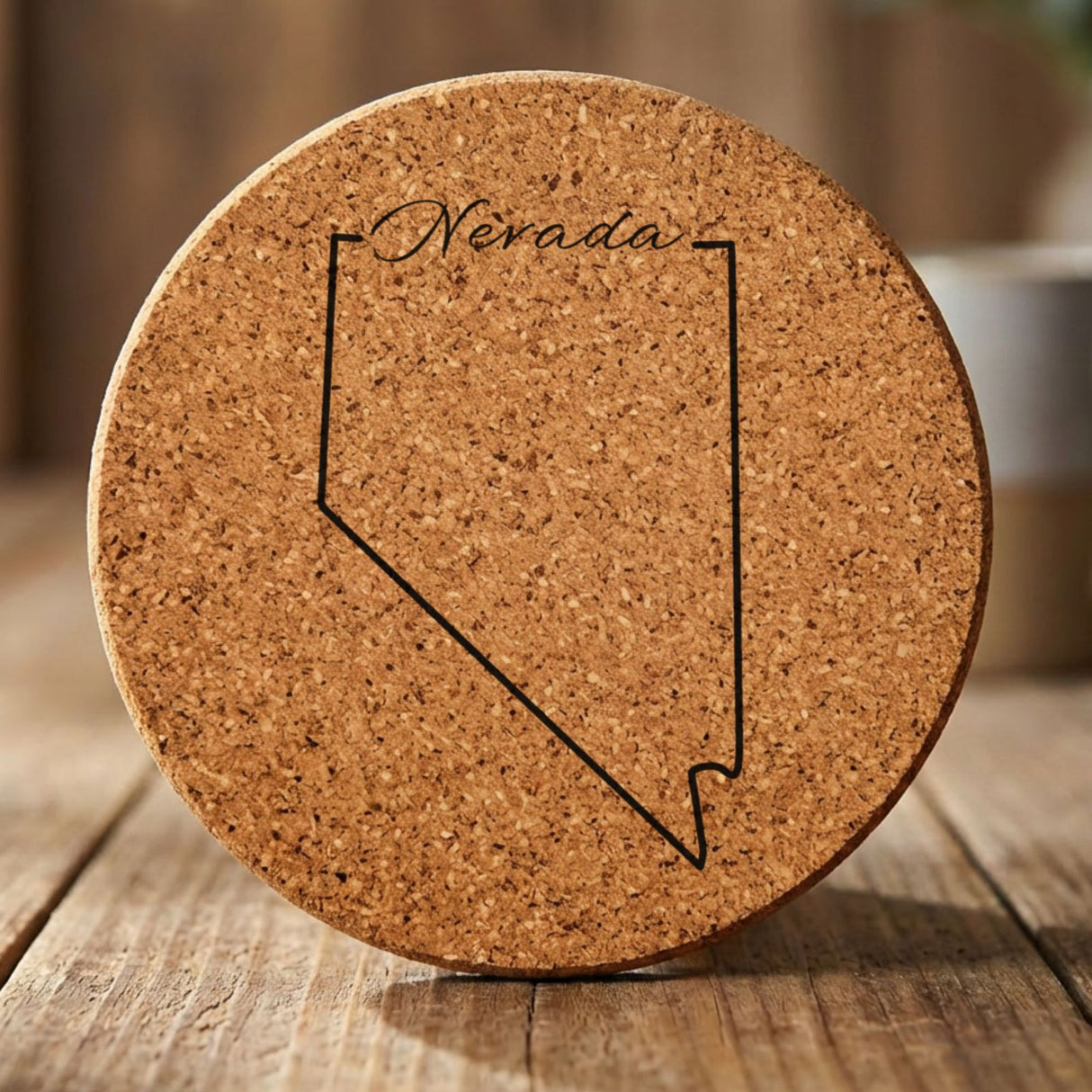 Nevada round cork coaster engraved with the state outline and Nevada in script lettering