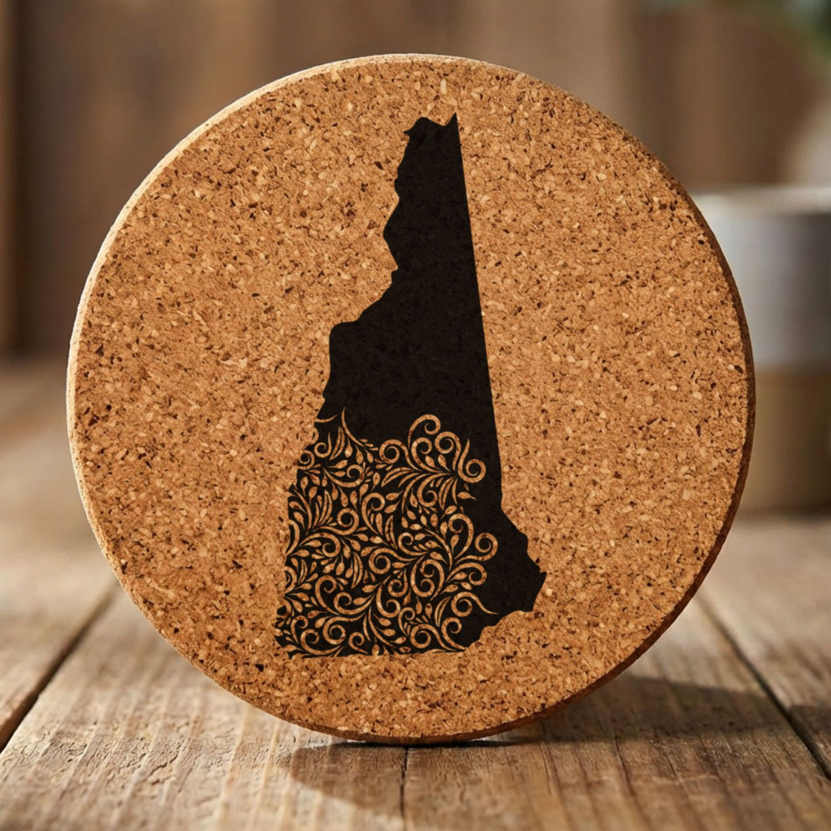 New Hampshire round cork coaster engraved with the state shape in ornate floral scrollwork