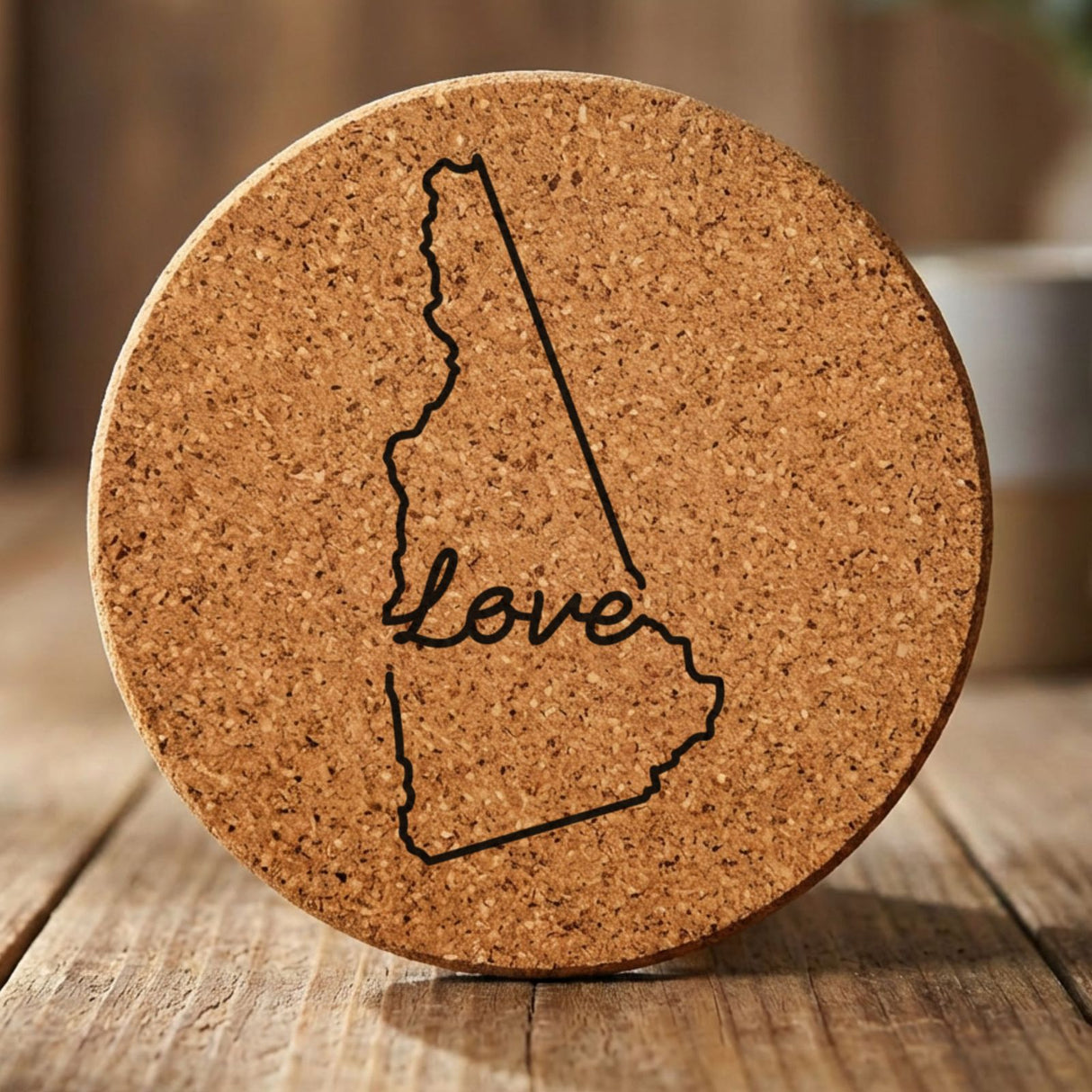 New Hampshire round cork coaster engraved with a hand-drawn state outline and love in cursive