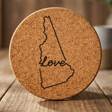 New Hampshire round cork coaster engraved with a hand-drawn state outline and love in cursive