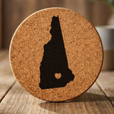 New Hampshire round cork coaster engraved with the state shape and a heart