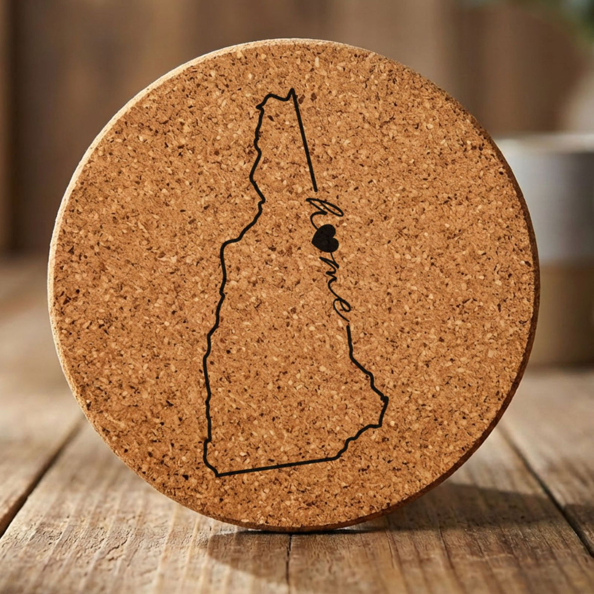 New Hampshire round cork coaster engraved with the state outline and home in script with a heart