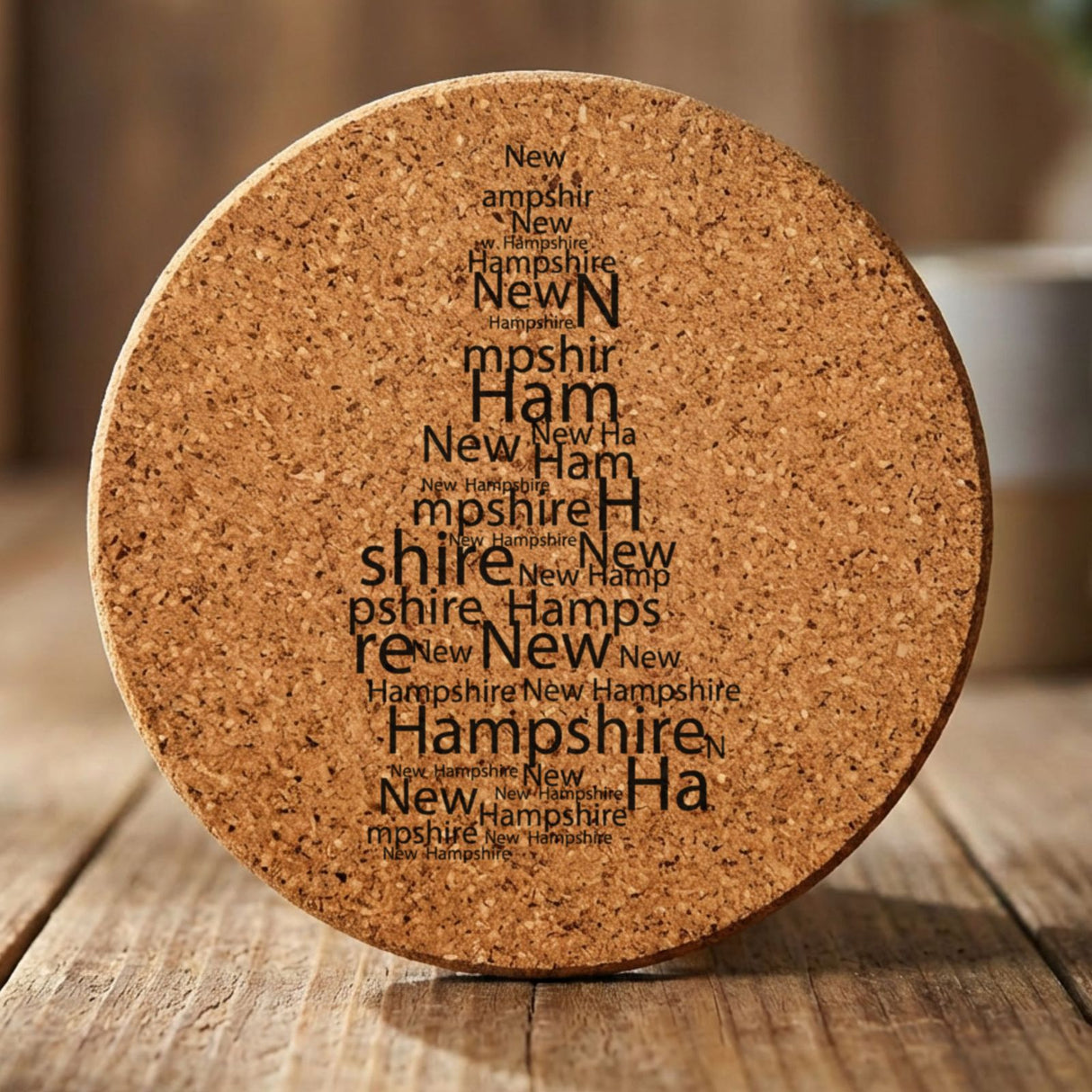 New Hampshire round cork coaster engraved with a word cloud of repeating New Hampshire text