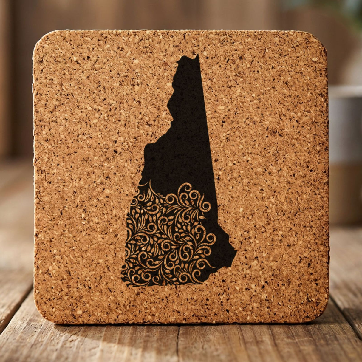 New Hampshire square cork coaster engraved with the state shape in ornate floral scrollwork