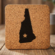 New Hampshire square cork coaster engraved with the state shape and a star