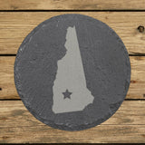 New Hampshire round slate coaster engraved with the state shape and a star
