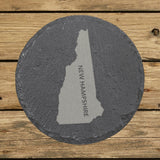New Hampshire round slate coaster with the engraved state shape and NEW HAMPSHIRE running vertically