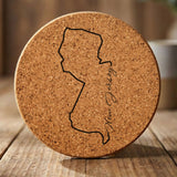 New Jersey round cork coaster engraved with the state outline and New Jersey in script lettering