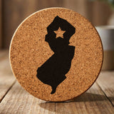 New Jersey round cork coaster engraved with the state shape and a star