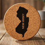 New Jersey round cork coaster with the engraved state shape and NEW JERSEY running vertically