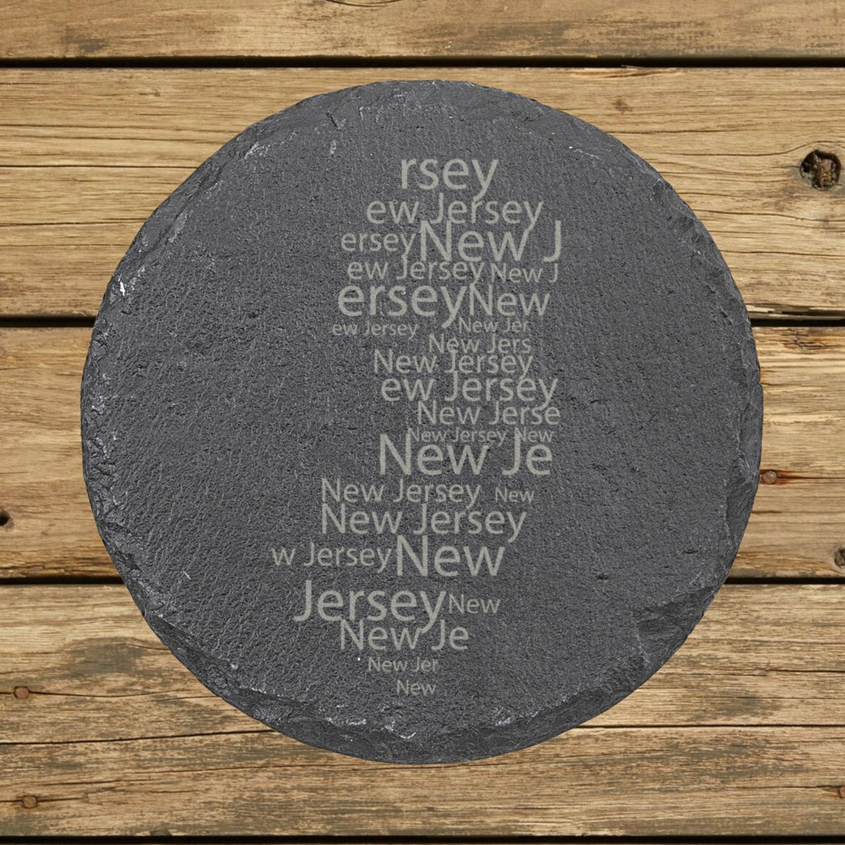 New Jersey round slate coaster engraved with a word cloud of repeating New Jersey text