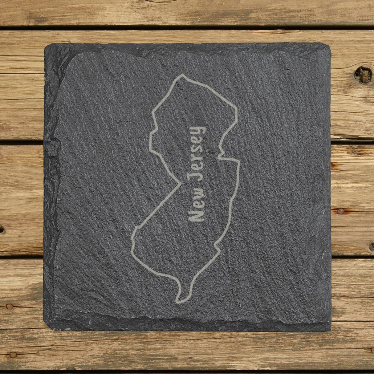 New Jersey square slate coaster engraved with the state outline and NEW JERSEY running vertically