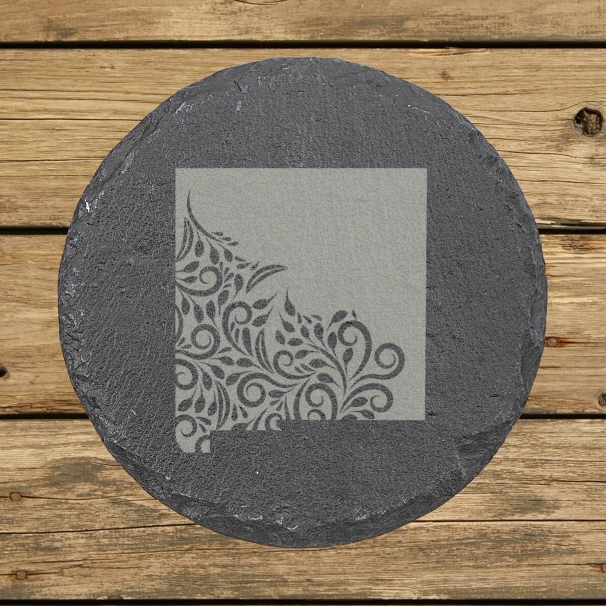 New Mexico round slate coaster engraved with the state shape in ornate floral scrollwork