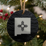 New Mexico round slate Christmas ornament engraved with the state outline and the Zia sun symbol