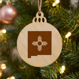 New Mexico round wood Christmas ornament engraved with the state outline and the Zia sun symbol