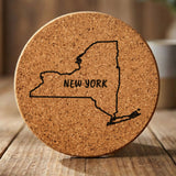 New York round cork coaster engraved with the state outline and NEW YORK in hand-drawn brush lettering