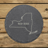 New York round slate coaster engraved with the state outline and NEW YORK in hand-drawn brush lettering