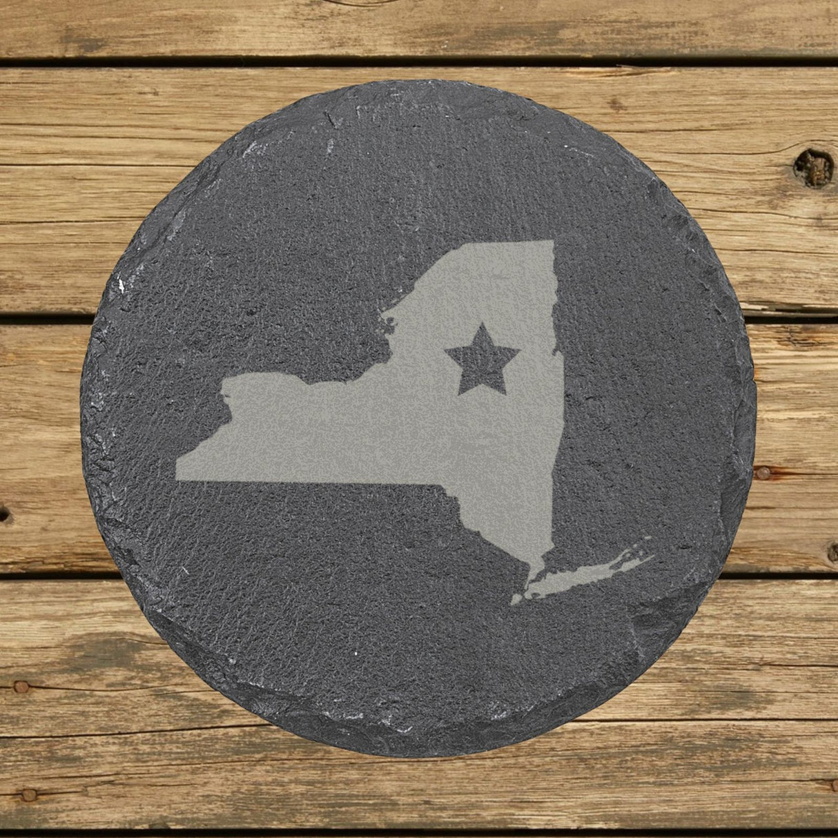New York round slate coaster engraved with the state shape and a star