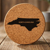 North Carolina round cork coaster engraved with the state shape and NORTH CAROLINA in bold lettering