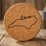 North Carolina round cork coaster engraved with a hand-drawn state outline and love in cursive