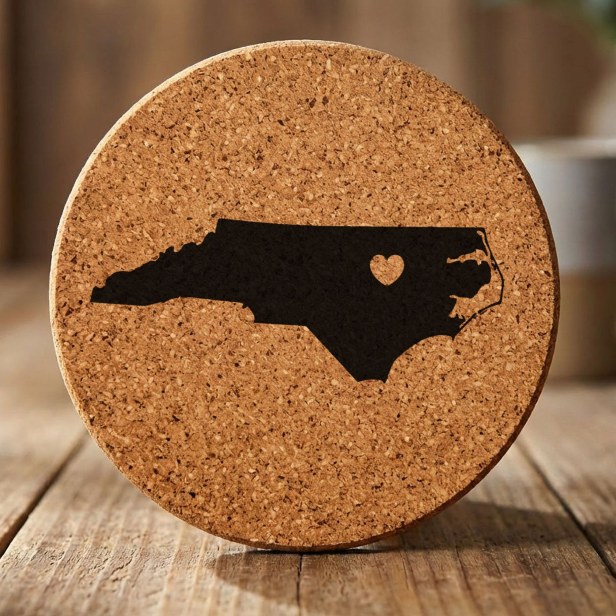 North Carolina round cork coaster engraved with the state shape and a heart