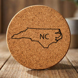North Carolina round cork coaster engraved with the state outline and NC initials