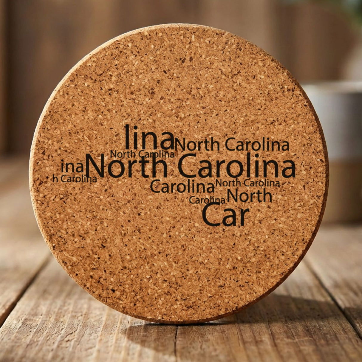 North Carolina round cork coaster engraved with a word cloud of repeating North Carolina text