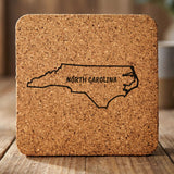 North Carolina square cork coaster engraved with the state outline and NORTH CAROLINA in hand-drawn brush lettering