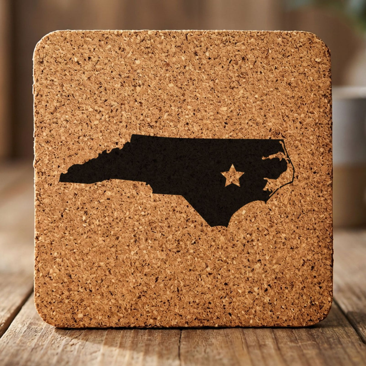 North Carolina square cork coaster engraved with the state shape and a star